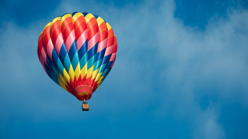 Brightly colored hot air balloon with a sky blue background